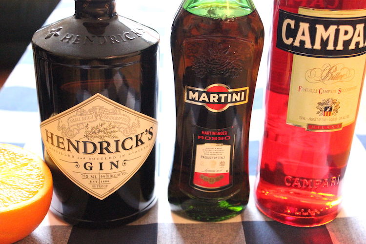 The ingredients for a negroni cocktail: campari, gin, and vermouth